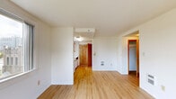 Located at 1212 SW Clay St in Portland, Oregon, this one-bedroom, one-bathroom unit offers a practical and efficient layout across a single floor. Light wood flooring runs throughout, giving the space a clean, cohesive look that brightens each room.

The kitchen is well-appointed with white cabinetry trimmed in warm wood tones, a full suite of white appliances including a refrigerator, electric range, and dishwasher, plus ample upper and lower cabinet storage. It opens directly into the dining area, creating a seamless flow for daily living.

The living room is a comfortable, open area filled with natural light from a sliding window that frames views of the surrounding neighborhood. Adjacent to the living space, a hallway connects to the bedroom and bathroom, keeping the layout organized and easy to navigate.

The bedroom is a well-proportioned private retreat featuring its own window with natural light and a sliding-door closet with built-in shelving. Two additional closets throughout the unit provide generous storage options — a notable feature for a space of this size.

The bathroom includes a wide vanity with a white countertop, under-sink cabinetry, a large mirror, and warm wood-accented trim details. The unit's neutral white walls and consistent flooring throughout contribute to a bright, tidy, and functional overall ambiance.