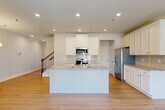 This well-appointed two-story home in Jonesboro, GA offers four bedrooms, three bathrooms, and a thoughtfully designed layout spread across two floors. The main level features an open-concept kitchen and living area with light hardwood-style flooring throughout. The kitchen is a standout, showcasing white shaker cabinetry, granite countertops, a subway tile backsplash, a center island with sink, and a full suite of stainless steel appliances. A staircase with classic wood banisters connects the floors, and a pendant chandelier illuminates the entry hallway. The living area includes French doors that open to the outdoors, filling the space with natural light. The upper level houses the generously sized primary bedroom along with three additional bedrooms, each carpeted and bathed in natural light from large windows. The primary bathroom features a dual-sink vanity with granite countertops, white cabinetry, and a glass-enclosed walk-in shower. Two additional bathrooms serve the remaining bedrooms. A spacious attached garage with an automatic opener completes this home, offering ample storage and parking. Clean neutral tones and consistent finishes throughout give the home a cohesive, move-in-ready feel.