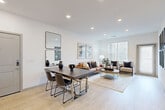 This thoughtfully designed single-floor residence offers a seamless blend of modern aesthetics and functional living across a well-organized floor plan. The open-concept kitchen and living area serves as the heart of the home, where light wood flooring ties the spaces together effortlessly. The kitchen is outfitted with sleek grey cabinetry, stainless steel appliances including a refrigerator, range, and microwave, white quartz countertops, and a central island with a sink — ideal for both everyday cooking and entertaining. Recessed lighting illuminates the space with a clean, contemporary feel.

The living room is bright and welcoming, featuring multiple windows with horizontal blinds that invite natural light while maintaining privacy. The bedroom offers plush carpeting, a window with natural light, and dedicated closet space, creating a comfortable and restful retreat. A versatile office provides a quiet workspace, complete with soft carpet and neutral walls. The full bathroom is finished in crisp white tones, featuring a tub-shower combination and wood-look tile flooring. Throughout the residence, a consistent neutral palette and modern design language create a cohesive and inviting atmosphere.