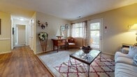 Located at 3600 Gateway Dr in Portsmouth, Virginia, this single-floor residence offers a well-organized layout with a warm, coastal-inspired aesthetic throughout. The living room serves as a welcoming gathering space, featuring wood-look flooring, a textured ceiling, and a sliding glass door that opens to an outdoor patio, allowing natural light to fill the room. Adjacent to the living area is a dedicated dining space appointed with chair-rail molding and the same wood-look flooring, creating a cohesive and polished feel.

The galley-style kitchen is efficiently designed with warm oak cabinetry, ample counter space, a gas range, stainless steel refrigerator, and in-unit laundry access, making everyday living highly convenient. The primary bedroom is generously sized, featuring plush carpet, neutral toned walls, and a large window that brings in abundant natural light with outdoor views. A second bedroom carries a charming nautical theme, complete with carpeted floors and a white dresser. Two full bathrooms round out the home — one styled with a coastal anchor motif and wood vanity, and the other with a clean, minimalist design with wood flooring and a tub-shower combination.