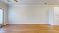Located at 1055 Winnall Ln in Fayetteville, NC, this single-story, one-bedroom, one-bathroom home offers a well-designed layout that maximizes functionality and comfort. The open-concept kitchen and living area serves as the heart of the home, featuring warm hardwood-style flooring, crown molding, and a ceiling fan. The kitchen is outfitted with white shaker-style cabinetry, light quartz countertops, a center island with a stainless steel undermount sink and pendant lighting, and a full suite of stainless steel appliances including a refrigerator, range, microwave, and dishwasher. The living area benefits from natural light and offers direct access to the outdoors through a set of French doors. The bedroom is a comfortable size, enhanced by a ceiling fan and window with natural light. The bathroom includes a full tub-shower combination with a curved curtain rod and chrome fixtures. Additional practical spaces include a dedicated laundry room with overhead wire shelving and utility hookups, multiple closets for ample storage, a hallway, and a utility room. Clean neutral walls and consistent flooring throughout give the home a cohesive, move-in-ready feel.