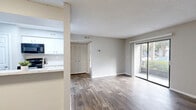 Located at Grand Pavilion Drive in Tampa, FL, this one-bedroom, one-bathroom unit offers a thoughtfully organized single-floor layout. Wood-look plank flooring runs consistently throughout the space, complementing the neutral gray tones of the walls and clean white trim, creating a cohesive and modern aesthetic.

The open living and dining area is bright and inviting, anchored by large sliding glass doors that flood the room with natural light and provide views of the surrounding greenery. A louvered closet door adds a functional storage element to the living space. The textured ceilings are present throughout the unit.

The galley-style kitchen is efficiently designed with white cabinetry, marble-look countertops, a stainless steel sink, and black appliances including a refrigerator, electric range, microwave, and dishwasher. It connects seamlessly to the dining area for ease of use.

The bedroom is a comfortable, well-proportioned retreat with a window that brings in natural light. It provides ample room for furnishings and connects conveniently to the rest of the unit via a hallway. Three closets throughout the unit offer generous storage capacity.

The bathroom features a white tub-shower combination, a marble-look vanity top with white cabinetry, and wood-look flooring. An in-unit laundry area adds everyday convenience to this practical Tampa residence.