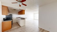 Located on the third floor at 464 S Berendo St in the Koreatown neighborhood of Los Angeles, this one-bedroom, one-bathroom unit offers a well-organized and functional layout across a single floor. The open-concept living and dining area flows seamlessly from the kitchen, creating a bright, airy feel enhanced by light wood laminate flooring and white walls throughout. A ceiling fan with overhead lighting serves the combined living space, while large windows dressed with vertical blinds allow generous natural light to fill the room. The kitchen features warm wood cabinetry, granite-style countertops, a double basin sink, tile flooring, and stainless steel appliances including a range and refrigerator, along with a convenient peninsula that opens to the living area. The spacious bedroom includes dual mirrored sliding closet doors that amplify light and space, with an additional window providing natural ventilation. Three closets in total offer excellent storage throughout the unit. The full bathroom is finished with tile flooring, a combined tub and shower with sliding glass doors, a pedestal-style vanity, and brushed nickel fixtures. A hallway connects the main living spaces, completing this efficient and comfortable floor plan.