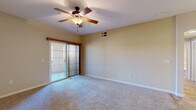 Located at 2606 Thomas Drive in El Centro, California, this single-story, one-bedroom, one-bathroom home offers a practical and well-appointed layout across a comfortable floor plan. The combined kitchen and living area forms the heart of the home, with the kitchen showcasing warm honey-toned cabinetry, granite countertops, recessed lighting, and a full suite of black appliances including a refrigerator, gas range with over-the-range microwave, and dishwasher. A peninsula counter with granite surface opens toward the living area, creating a seamless flow between cooking and living spaces. The living room is finished with plush carpet, a ceiling fan, and a sliding glass door fitted with vertical blinds that allows natural light and outdoor access. The bedroom is generously sized, featuring the same soft carpeting, a ceiling fan, a tray ceiling detail, and its own sliding glass door to the exterior. A dedicated closet with built-in shelving provides ample storage. The bathroom includes a wood-cabinet vanity with a large mirror, a three-light fixture, and tile flooring. A separate laundry area houses a full-size washer and dryer with overhead cabinetry above. Throughout the home, neutral tones and tile flooring in the wet areas contribute to a clean, functional aesthetic.