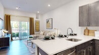 Located at 100 Sobel Dr E in Old Bridge, NJ, this well-appointed one-bedroom, one-bathroom residence offers a thoughtfully designed single-floor layout with modern finishes throughout. The open-concept kitchen and living area serves as the heart of the home, where dark espresso-toned shaker cabinetry contrasts beautifully against bright white quartz countertops and a classic subway tile backsplash. A full suite of stainless steel appliances — including a gas range, over-the-range microwave, dishwasher, and refrigerator — completes the kitchen. The peninsula counter flows seamlessly into the living area, which is bathed in natural light from a sliding glass door that opens to an outdoor view. The generously sized primary bedroom features light wood-tone flooring, a large window, and ample space for a full furniture arrangement. The full bathroom is clean and contemporary, finished with large-format tile flooring, a soaking tub with shower, and a white quartz vanity. A dedicated in-unit laundry room with side-by-side washer and dryer adds everyday convenience. Recessed lighting, light hardwood-style flooring, and crisp white walls tie the entire space together with a cohesive, modern aesthetic.