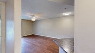 Located at 2335 W. Seminole Boulevard in Sanford, FL, this efficiently designed 1-bedroom, 1-bathroom apartment offers 560 square feet of single-floor living space. The living room features rich hardwood flooring, a textured ceiling, a ceiling fan with light fixture, and a sliding glass door that fills the space with natural light and provides views of the surrounding greenery. The kitchen is well-appointed with dark espresso cabinetry, granite-style countertops, a decorative mosaic tile backsplash, stainless steel appliances including an electric range and over-the-range microwave, and light tile flooring. The primary bedroom spans 160 square feet and is finished with plush wall-to-wall carpeting, a ceiling fan, a closet, and a sliding glass door offering additional outdoor access and natural light. The bathroom includes a full tub/shower combo with white tile surround, a vanity with dark cabinetry and granite-style countertop, and tile flooring. A dedicated laundry area houses a full-size washer and dryer alongside a water heater, complemented by wire shelving for added storage. Ceiling fans are present throughout the unit, enhancing comfort year-round.