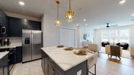 Located at 270 Tallassee Rd in Athens, Georgia, this single-floor residence blends contemporary design with thoughtful detail across every room. The open-concept kitchen serves as a standout centerpiece, showcasing bold navy shaker cabinetry paired with a crisp white subway tile backsplash, a striking veined quartz island with seating for multiple guests, and a full suite of stainless steel appliances. A pair of sculptural gold pendant lights add a sophisticated decorative touch overhead, while large-format marble-look tile flooring extends seamlessly through the kitchen and into the adjacent dining area.

The living space is bright and welcoming, with large windows drawing in generous natural light and warm hardwood flooring that flows throughout. The bedrooms feature elegant board-and-batten accent walls, hardwood floors, ceiling fans with recessed lighting, and ample windows that provide pleasant outdoor views, creating a calm and comfortable retreat.

The bathroom is finished to a high standard, with the same large-format tile, a frameless sliding glass shower enclosure, white subway tile surround with built-in niche, and sleek matte black hardware accents. Throughout the home, a cohesive palette of soft whites, warm woods, and navy accents creates a polished, modern ambiance that is both inviting and refined.