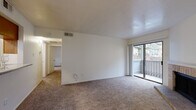 This efficiently designed single-floor residence offers four bedrooms and two bathrooms within a well-organized layout. The living room serves as the heart of the home, featuring a tile-surround fireplace, plush carpeting, and a sliding glass door that opens to a private balcony with outdoor views. Adjacent to the living room, the dining area features warm hardwood-style flooring and a central pendant light fixture, creating a welcoming atmosphere for meals. A chair rail adds a subtle architectural detail to the space.

The galley-style kitchen is outfitted with warm wood cabinetry, granite-look countertops, a double sink, and white appliances including a range and refrigerator. A pantry provides additional storage, and hardwood-style flooring continues throughout the kitchen for easy maintenance.

The four bedrooms are carpeted and well-lit, with the primary bedroom offering a comfortable footprint and natural light through window blinds. Both bathrooms include wood-toned vanity cabinetry and granite-style countertops, with hardwood-style flooring. A dedicated laundry area and utility room add further practicality. The hallway connects all rooms in a logical flow, making this home functional and easy to navigate.