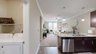 Located at 906 Oasis Palm Cir in Ocoee, FL, this single-floor, one-bedroom, one-bathroom residence offers a thoughtfully designed open-concept layout. The combined kitchen and living area forms the heart of the home, where rich dark-espresso cabinetry, granite countertops, and a full suite of stainless steel appliances — including a refrigerator, range, microwave, and dishwasher — define the kitchen. A peninsula with bar seating and pendant lighting makes for an ideal casual dining spot. Crown molding and wood-style flooring add a polished touch throughout the main living areas. The spacious living room is bathed in natural light from large windows and features plush carpeting and a ceiling fan. The bedroom offers a serene retreat with dual windows overlooking a balcony, soft carpeting, and a ceiling fan. The full bathroom includes a tub-shower combination with tiled surround, a granite-topped vanity with dark wood cabinetry, and wood-style flooring. A dedicated laundry area houses a full-size washer and dryer. Hallways connect all areas efficiently, and a closet provides additional storage. Warm neutral tones throughout create a cohesive, inviting ambiance.
