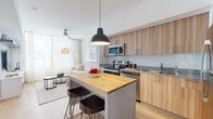 Located at 18036 Park Row Dr in Houston, TX, this well-designed one-bedroom, one-bathroom unit maximizes its compact footprint with a thoughtful, open-concept layout. Light wood flooring flows throughout, lending warmth and visual continuity across every room.

The kitchen and living area share an open, airy space anchored by a central island with a butcher block top and seating for two — ideal for casual dining or entertaining. The kitchen is outfitted with light wood cabinetry extending to the ceiling, granite countertops, a white subway tile backsplash, and a full suite of stainless steel appliances. A bold black pendant light adds a modern focal point overhead.

The living area is bright and welcoming, with large windows dressed in sheer white curtains that filter generous natural light. The neutral palette creates a calm, cohesive atmosphere throughout.

The bedroom is a cozy retreat featuring a large window with sheer curtains, light wood flooring, and a floating media shelf with ample storage. The space is compact yet efficiently arranged.

The bathroom continues the modern aesthetic with a wood-toned vanity, granite countertop, and a full tub-shower combination framed by neutral tile surround. A dedicated closet completes the unit's practical layout. Overall, the space balances style and functionality with a clean, contemporary design.