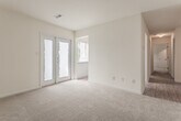 This single-floor residence at 14531 Old Courthouse Way in Newport News, Virginia, offers a practical and well-organized layout across several distinct living spaces. The living area is generously sized, finished with neutral-toned carpet, and features French doors that invite natural light while providing access to an outdoor space. An additional window further brightens the room, creating an open and airy atmosphere.

The kitchen is equipped with warm-toned wooden cabinetry, light countertops, a stainless steel sink, and white appliances including a dishwasher, electric range, and overhead ventilation. Wood-look flooring runs throughout the kitchen, adding a clean, durable surface underfoot.

The bedrooms are carpeted and neutral in tone, each offering comfortable proportions and ample natural light through slatted blinds. At least one bedroom includes a walk-in closet, while others feature standard closets, providing practical storage solutions throughout.

The bathrooms include a full bath with a soaking tub and shower combination featuring chrome fixtures and a towel bar, as well as a second bathroom with a wood-toned vanity, large mirror, and overhead lighting. Wood-look flooring in the bathrooms complements the overall design aesthetic of the home.