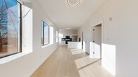 Located at 540 Bond Street in Bridgeport, CT, this thoughtfully designed one-bedroom, one-bathroom unit offers a clean, modern aesthetic throughout. Light-toned hardwood flooring runs continuously across the entire space, complementing the crisp white walls and creating a bright, cohesive feel.

The open-concept living and kitchen area forms the heart of the unit. The kitchen is outfitted with white shaker cabinetry, gold hardware, dark countertops, a tile backsplash, and a full suite of stainless steel appliances, including a refrigerator, range, microwave, and dishwasher. A central island provides additional prep space, while multiple large windows along the living area flood the space with natural light and offer views of the surrounding neighborhood streetscape and mature trees.

A hallway connects the main living area to the private bedroom, which is a well-proportioned room with its own window and access to a dedicated closet with built-in shelving and hanging rods. Four closets in total provide exceptional storage throughout the unit.

The bathroom features a full tub-shower combination with matte black fixtures, terrazzo-style tile flooring, and a sage green vanity, adding a subtle pop of color to the otherwise neutral palette. The overall design is clean, contemporary, and move-in ready.