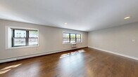 Located on North Sheridan Road in Chicago's Edgewater neighborhood, this 2-bedroom, 2-bathroom residence offers a well-designed single-floor layout with thoughtful finishes throughout. Rich, dark hardwood floors run continuously through the living, dining, and bedroom areas, creating a warm and cohesive aesthetic against the neutral gray-toned walls.

The open living and dining area is generously proportioned, bathed in natural light through multiple windows that frame neighborhood views. Baseboard heating and in-unit climate control units provide year-round comfort. Recessed lighting complements the natural light throughout.

The kitchen features dark lower cabinetry contrasted by white upper cabinets, stone countertops, a white subway tile backsplash, and stainless steel appliances, including a range and over-the-range microwave.

The primary bedroom offers a comfortable footprint with a window and wall-to-wall closet with built-in shelving. A dedicated laundry room with a stacked washer and dryer is conveniently accessible from the bedroom area. The second bedroom also includes a window and individual climate control.

Both bathrooms are tastefully updated. One features full subway tile surround, a soaking tub, and a window. The other includes a stone-topped vanity, an octagonal mirror, and modern matte black fixtures. Four closets throughout the unit provide ample storage.