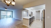 Located at 101 Steuben Dr. in Albany, NY, this well-appointed single-floor residence offers one bedroom, two bathrooms, and a thoughtfully designed layout spanning a comfortable footprint. The open-concept living, dining, and kitchen area serves as the heart of the home. The kitchen is a standout, featuring crisp white shaker cabinetry, striking marble-look countertops, a central peninsula, and stainless steel appliances including a refrigerator, range, microwave, and dishwasher — all illuminated by recessed lighting. The dining area flows naturally from the kitchen and is accented by an elegant chandelier and light hardwood-style flooring that continues throughout the main living spaces. The living room is bright and airy, with large sliding glass doors dressed in vertical blinds that invite natural light and provide views of the surrounding greenery. The generously sized primary bedroom features soft carpeting, a ceiling fan, a dedicated closet, and a window overlooking the outdoors. Both bathrooms are clean and functional, with one featuring a glass-enclosed walk-in shower. A dedicated closet adds to the practical storage throughout. Baseboard heating is present throughout, and neutral tones give the entire residence a move-in-ready, versatile feel.