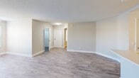 Located at 2155 Great Blue Dr. in Naples, FL, this 3-bedroom, 2-bathroom unit offers a well-designed, single-floor layout that maximizes functionality. The open-concept living and kitchen area serves as the heart of the home, featuring light gray wood-look flooring, neutral beige walls, and a textured ceiling. The kitchen is well-appointed with white shaker-style cabinetry, light countertops, stainless steel appliances including a range, microwave, and refrigerator, and a peninsula with a double-basin sink that opens to the living area. The living space is bright and open, with natural light filtering in through windows fitted with white blinds. The three bedrooms offer plush carpeting, ceiling fans, and windows with outdoor views of surrounding greenery. The primary bedroom provides a comfortable, private retreat. Both bathrooms are finished in crisp white tones, featuring vanities with white cabinetry, large mirrors, and wood-look flooring. A dedicated laundry room houses a full-size washer and dryer with overhead wire shelving for additional storage. A hallway and closet round out the layout, providing practical storage solutions throughout this clean, move-in-ready Naples residence.