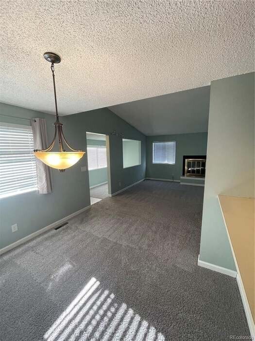Dining room view of the living room and office by the front door, overlooking the deck. - 6700 E Mississippi Ave