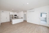 Located at 2039 East 8th Street in National City, CA, this thoughtfully designed one-bedroom, one-bathroom unit offers a clean, modern aesthetic throughout its efficiently organized single-floor layout. Light wood-look flooring flows seamlessly across all living areas, complementing the bright white walls and creating a fresh, contemporary feel.

The open-concept living and dining area is bathed in natural light through large windows that frame outdoor views of the surrounding neighborhood, including palm trees and neighboring buildings. A wall-mounted mini-split system provides climate control in both the living area and bedroom. The kitchen features a peninsula with a quartz-style countertop, undermount sink with a matte black pull-down faucet, white shaker-style cabinetry with black hardware, a marble-look tile backsplash, and a full suite of stainless steel appliances including a refrigerator, range, and microwave.

The bedroom is a well-proportioned retreat with multiple windows offering ample natural light and outdoor views, its own mini-split unit, and direct access to a closet. The bathroom is clean and functional, featuring a combination tub and shower, white vanity, and wood-look flooring. Additional spaces include a dedicated laundry area, utility room, and hallway. A private balcony completes this well-appointed unit.