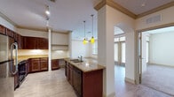Located at 921 S Orlando Ave in Maitland, Florida, this single-floor residence offers a well-designed layout with a thoughtful blend of finishes and functional living spaces throughout. The kitchen serves as a central highlight, featuring rich dark wood cabinetry with decorative beadboard detailing, granite countertops, stainless steel appliances including a refrigerator and over-the-range microwave, a black electric range, and a center island with a double stainless sink and pendant lighting overhead. Track lighting and crown molding add refined character to the space. An elegant arched passageway connects the kitchen to the living area, which is finished with wood-style flooring, crown molding, a ceiling fan, and large windows and glass doors that invite abundant natural light and outdoor views. The bedrooms are carpeted and comfortably sized, each with ceiling fans and windows. The primary bedroom includes a walk-in closet with built-in shelving. The primary bathroom offers a dual-sink granite vanity with dark wood cabinetry, a tiled walk-in shower, and wood-style flooring. A secondary bathroom features a matching granite vanity and tiled accents. Together, these spaces create a cohesive, well-finished living environment in a desirable Maitland location.
