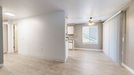 Located at 540 SW 257th Ave in Troutdale, Oregon, this two-bedroom, one-bathroom single-story home offers a practical and well-organized layout with a neutral color palette throughout. The living area flows directly into the kitchen, which features white cabinetry with wood-tone trim, granite-look countertops, and white appliances including a range and refrigerator, all set atop light-toned luxury vinyl plank flooring. A ceiling fan with lighting anchors the living space, which receives natural light through a window with blinds. The hallway connects the main living areas to the bedrooms and bathroom, and also provides access to in-unit laundry. Both bedrooms are finished with plush carpet and feature windows with blinds that allow for natural light. The primary bedroom offers a comfortable footprint with a reach-in closet. The bathroom is equipped with a full-size soaking tub and shower surround. Clean white walls and crisp baseboards are consistent throughout, lending a fresh and move-in-ready feel to the home. The overall design is straightforward and functional, making efficient use of the available space.