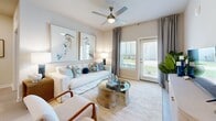 Located at 360 Orleans Ave in Santa Rosa Beach, FL, this well-appointed 2-bedroom, 2-bathroom residence offers a thoughtfully designed single-floor layout with a light, coastal aesthetic throughout. The open-concept kitchen and living area serves as the heart of the home, anchored by a granite-topped island with bar seating illuminated by pendant lighting. The kitchen is outfitted with crisp white cabinetry, stainless steel appliances — including a French door refrigerator, electric range, and built-in microwave — and light wood-look flooring that extends seamlessly into the living room. The living area is bright and airy, with natural light streaming in through large windows dressed in soft draping curtains and a ceiling fan overhead. The primary bedroom is a serene retreat featuring coastal-inspired décor, natural light from dual windows, and a ceiling fan, accompanied by a spacious walk-in closet with wire shelving. The second bedroom offers comparable comfort and light. Both bathrooms echo the home's design language with granite vanity tops and white cabinetry. A dedicated in-unit laundry room with a full-size washer and dryer adds everyday convenience. Neutral tones and coastal touches create a calm, inviting ambiance throughout.