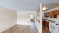 Located at 645 Winnie Street in Lexington, KY, this one-bedroom, one-bathroom unit offers a practical and efficiently designed single-floor layout. Wood-style plank flooring runs throughout, providing a warm and cohesive look across all living areas. The open-concept living and dining space is bright and functional, with neutral cream-toned walls and a textured ceiling that adds a classic touch. A wall-unit HVAC system and baseboard heating ensure year-round comfort, while windows allow natural light to fill the rooms. The kitchen is thoughtfully positioned adjacent to the living area, separated by a half-wall with a breakfast bar countertop. It features warm wood-toned cabinetry, a white refrigerator, and a range, offering everything needed for everyday cooking. The bedroom is a comfortable, well-proportioned retreat with a window overlooking the exterior and a baseboard heater. Notably, the unit includes an impressive four closets, providing generous storage options rarely found in similarly sized spaces. The full bathroom includes a soaking tub with a grab bar, a vanity with wood cabinetry, a medicine cabinet mirror, and tile flooring, combining practicality with comfort. This unit presents a well-rounded living space in a convenient Lexington location.