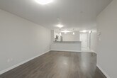 Located at 996 Paisley Rd in Guelph, Ontario, this well-designed one-bedroom, one-bathroom unit offers a thoughtful open-concept layout finished with neutral tones and durable laminate hardwood flooring throughout the main living areas. The kitchen is a standout feature, equipped with white cabinetry, dark countertops, stainless steel appliances including a refrigerator, microwave, and dishwasher, and an extended peninsula with pendant lighting overhead — ideal for casual dining or entertaining. The kitchen flows seamlessly into the combined dining and living area, which is generously proportioned and filled with natural light, with direct sliding door access to a private balcony offering outdoor views. The bedroom is a comfortable, well-sized retreat featuring mirrored sliding closet doors and a window that brings in additional natural light. The full bathroom includes a soaker tub and shower combination with clean, bright finishes. A dedicated in-suite laundry room with full-sized washer and dryer adds everyday convenience. The unit's consistent use of light, neutral walls and clean white trim gives the entire space a fresh, contemporary ambiance throughout.