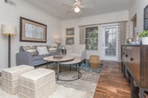 Located on Walden Brook Drive in Lithonia, Georgia, this single-floor residence offers a thoughtfully designed layout that balances functionality and comfort. Rich hardwood-style flooring runs throughout the main living areas, providing a warm and cohesive aesthetic from room to room.

The kitchen is a standout feature, outfitted with white cabinetry, light countertops, and a built-in peninsula with seating — ideal for casual dining or meal prep. A double sink is integrated into the peninsula, and the space is equipped with a full suite of appliances including a range and dishwasher. Crown molding and a textured ceiling add classic detail, while an overhead light fixture keeps the area bright and welcoming.

A dedicated dining area sits adjacent to the kitchen, defined by a pendant light overhead and framed wall art that adds character to the space. The entry foyer features a decorative mirror with a wood-tone frame and connects smoothly to the rest of the home. Hallways lead to multiple rooms with panel-style doors and clean white trim throughout.

The living area offers an open feel with access to the bedroom, which is visible through the hallway and appears generously sized. Double closet doors along the corridor provide ample storage. The overall ambiance of the home is clean, neutral, and move-in ready, with a layout that makes efficient use of every square foot.