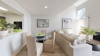 The Arrowhead is a two-story, 2-bedroom, 2-bathroom residence that combines a clean, neutral aesthetic with practical design throughout. The main living area features light wood-look flooring in a herringbone pattern, a textured ceiling, and recessed lighting, creating a bright and welcoming atmosphere. The open layout seamlessly connects the living and dining areas, where a glass-top dining table sits alongside a plush sectional sofa, making the space well-suited for both relaxing and entertaining.

The kitchen is equipped with light quartz countertops, dark cabinetry, and black appliances, including a full-size refrigerator, offering a functional contrast of tones. Both bedrooms are carpeted and generously sized. The primary bedroom features a bold accent wall, walk-in closet, and direct access to an en-suite bathroom. The second bedroom also includes a walk-in closet and is served by a well-appointed full bathroom featuring wood-look flooring, a tub-shower combination, and clean white finishes. Both bathrooms maintain a consistent, understated style. Throughout the home, neutral wall tones and curated artwork contribute to a cohesive, modern ambiance.