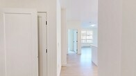 This thoughtfully designed 2-bedroom, 2-bathroom unit at 20191 53A Avenue offers a functional and modern living experience across a single floor. The open-concept kitchen is a standout feature, boasting crisp white cabinetry with matte black hardware, quartz countertops, a subway tile backsplash, stainless steel appliances including a built-in microwave, range, dishwasher, and refrigerator, as well as a central island with stylish pendant lighting overhead. Light hardwood flooring flows through the kitchen and living area, creating a bright and cohesive atmosphere. The living space includes a large window that brings in generous natural light and overlooks the surrounding residential neighbourhood. Both bedrooms are finished with plush carpet and clean white walls, with the primary bedroom offering a dedicated closet with bi-fold doors. The two bathrooms are finished in neutral tones — one featuring a glass-enclosed walk-in shower with tile surround, and the other a full soaker tub with tiled walls. A private covered patio, accessible via sliding glass doors, extends the living space outdoors and overlooks a landscaped area with mature greenery and views of the neighbouring community. Two closets provide additional storage throughout the unit.