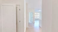 This thoughtfully designed 2-bedroom, 2-bathroom unit at 20191 53A Avenue offers a functional and modern living experience across a single floor. The open-concept kitchen is a standout feature, boasting crisp white cabinetry with matte black hardware, quartz countertops, a subway tile backsplash, stainless steel appliances including a built-in microwave, range, dishwasher, and refrigerator, as well as a central island with stylish pendant lighting overhead. Light hardwood flooring flows through the kitchen and living area, creating a bright and cohesive atmosphere. The living space includes a large window that brings in generous natural light and overlooks the surrounding residential neighbourhood. Both bedrooms are finished with plush carpet and clean white walls, with the primary bedroom offering a dedicated closet with bi-fold doors. The two bathrooms are finished in neutral tones — one featuring a glass-enclosed walk-in shower with tile surround, and the other a full soaker tub with tiled walls. A private covered patio, accessible via sliding glass doors, extends the living space outdoors and overlooks a landscaped area with mature greenery and views of the neighbouring community. Two closets provide additional storage throughout the unit.