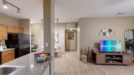 This thoughtfully designed single-story residence in San Antonio, Texas, offers a comfortable and functional layout across one bedroom and one bathroom. The open-concept kitchen and living area serves as the heart of the home, featuring light wood-tone flooring throughout. The kitchen is equipped with warm wood cabinetry, granite countertops, black appliances including a range, microwave, and refrigerator, and track lighting overhead. A cozy dining nook with built-in shelving sits just adjacent, perfect for casual meals. The living room is bright and inviting, with a ceiling fan, large windows, and glass patio doors that open to an outdoor view, filling the space with natural light. Warm neutral tones carry throughout, creating a cohesive and relaxing ambiance. The generously sized bedroom features plush carpeting, a ceiling fan, and a bay-style window that allows ample natural light. A dedicated closet provides organized storage. The bathroom offers a wide vanity with warm wood cabinetry and a well-lit mirror. A separate laundry area with a full-size washer and dryer adds everyday convenience. A hallway connects all rooms seamlessly, completing this efficient and welcoming floor plan.