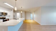 Located at 1708 Starship Dr in Cocoa, FL, this well-appointed single-story home offers three bedrooms, two bathrooms, and a thoughtfully designed open floor plan. The heart of the home is a bright, modern kitchen featuring white shaker cabinetry, stainless steel appliances including a refrigerator, range, and microwave, a subway tile backsplash, and a large center island with a sink and light countertops illuminated by pendant lighting. The kitchen flows seamlessly into the living room, which is finished with light wood-style flooring, a ceiling fan, and a glass door leading to a balcony with outdoor views. A built-in entry nook with coat hooks adds a functional touch near the entrance. The bedrooms are carpeted and feature ceiling fans, ample natural light, and well-organized closets with wire shelving systems. The generous primary bedroom includes its own closet space. Bathrooms are clean and modern, with light wood flooring, a tiled walk-in shower, and vanity storage with brushed nickel hardware. A dedicated laundry room houses a full-size Whirlpool washer and dryer with overhead shelving. Light wood flooring and neutral tones throughout create a cohesive, bright ambiance across the entire home.