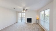 Located at 1221 Chisholm Valley Dr in Round Rock, TX, this well-laid-out one-bedroom, one-bathroom residence offers a comfortable and functional living environment across a single floor. The living room serves as the heart of the home, featuring soft carpeting, a ceiling fan with light fixture, and a classic wood-burning fireplace framed in white — an inviting focal point for the space. Natural light flows in through multiple windows fitted with horizontal blinds, while sliding glass doors with vertical blinds provide direct access to an outdoor balcony area. The kitchen is positioned adjacent to the living area and features a gas range, overhead ventilation hood, and a breakfast bar counter, making it both practical and accessible. A carpeted hallway connects the main living areas to the private bedroom, which is a comfortable size and includes a ceiling fan, a sliding glass door for additional natural light, and access to a dedicated closet. The bathroom is clean and straightforward, offering a full-size tub-shower combination with white tile surround. Throughout the residence, neutral white walls, textured ceilings, and consistent carpeting create a cohesive and move-in-ready aesthetic suitable for a variety of lifestyles.