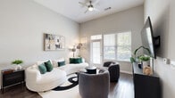 Located at 1385 Classic Ct in Mount Pleasant, SC, this well-appointed one-bedroom, one-bathroom residence offers a thoughtfully designed single-level layout. The living room is an immediate highlight, featuring soaring ceilings, rich dark hardwood flooring, and generous natural light streaming through large windows with plantation shutters. A ceiling fan adds comfort, while a private exterior door opens the space further. The kitchen is outfitted with dark espresso cabinetry, crisp white countertops, a subway tile backsplash, and a full suite of stainless steel appliances including a refrigerator, electric range, and built-in microwave. A peninsula with bar seating provides additional functionality and separates the kitchen from the main living area. The bedroom benefits from the same soaring ceiling profile, dual windows for abundant natural light, and ample room for a full furniture arrangement. The bathroom continues the dark cabinetry theme, featuring a wide vanity with white countertop, a large mirror, and hardwood-style flooring. A dedicated closet and hallway complete the floorplan. Neutral gray walls throughout lend a cohesive, modern aesthetic to this well-designed residence.
