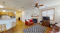 Located at 734 Jupiter Dr in Madison, Wisconsin, this single-floor home offers a well-designed, functional layout with warm finishes throughout. Hardwood-style flooring flows from the welcoming entry hallway into the open-concept living and kitchen area, creating a cohesive and airy feel. The living room is a central highlight, featuring a tiled gas fireplace with a wood mantel, a ceiling fan, and large windows fitted with wood-trimmed blinds that allow ample natural light. A full-length sliding glass door opens directly onto a private outdoor deck, extending the living space outdoors. The kitchen is equipped with warm oak cabinetry, a subway tile backsplash, stainless steel appliances, and a peninsula breakfast bar with pendant lighting — ideal for casual dining or entertaining. A dedicated hallway connects the main living areas to the private quarters, which include multiple bedrooms. Each bedroom features plush carpeting, ceiling fans, and windows with outdoor views. The bathroom offers a wide vanity with oak cabinetry, a large mirror, and bright overhead lighting. Throughout the home, a consistent use of warm wood tones, white walls, and natural light contributes to a comfortable and inviting atmosphere.