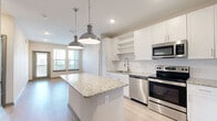 Located at 7950 Park Blvd N in Pinellas Park, Florida, this single-floor, 2-bedroom, 2-bathroom residence offers a thoughtfully designed layout across a comfortable footprint. The kitchen serves as a central highlight, boasting a large granite-topped island with pendant lighting, crisp white cabinetry, stainless steel appliances, a tile backsplash, and light wood-look flooring that extends into the living area. Natural light flows in through multiple windows, enhancing the open feel of the main living space. The generously sized primary bedroom features plush carpeting and a ceiling fan, and connects directly to a private en-suite bathroom. The primary bathroom is well-equipped with a dual-sink vanity topped with granite counters, white cabinetry, wood-look tile flooring, and a full soaking tub. A dedicated walk-in closet with wire shelving provides ample storage. The second bedroom is equally comfortable, offering carpeted floors, a ceiling fan, and a window with outdoor views. A second walk-in closet with wire shelving adds further storage convenience. Both bedrooms and closets are well-proportioned, making this residence a practical and inviting home in Pinellas Park.