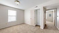 Located at 1717 N Main St in McPherson, Kansas, this one-bedroom, one-bathroom unit offers a practical and well-organized single-floor layout. The living area is carpeted and bathed in natural light through large windows fitted with blinds, creating a bright and welcoming atmosphere with a neutral color palette throughout.

The galley-style kitchen is efficiently designed, featuring warm honey-toned wood cabinetry on both sides, light countertops, a gas range, refrigerator, dishwasher, and a built-in sink — all set over durable tile flooring. Overhead cabinetry maximizes storage, making the kitchen both functional and organized.

The bedroom is generously proportioned and includes a ceiling fan, a dedicated closet, and direct access to the full bathroom. The bathroom is fitted with a full-size soaking tub and shower combination with chrome fixtures. Soft carpeting and multiple windows in the bedroom allow for ample natural light and comfortable living.

A dedicated laundry area houses a full-size washer and dryer, adding everyday convenience. The unit also includes a hallway and additional closet space, contributing to its smart use of space. The clean, neutral finishes throughout make this a move-in ready home in a straightforward residential setting.