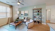 Located at 118 Shellbark Way in Savannah, Georgia, this single-story, 2-bedroom, 2-bathroom residence offers a thoughtfully designed layout that balances comfort and functionality. The open-concept living, dining, and kitchen area serves as the heart of the home, bathed in natural light from multiple windows dressed with sheer linen curtains. The living room features light hardwood-style flooring, a ceiling fan, and a soft sage accent wall that lends a calm, inviting ambiance. The kitchen is equipped with stainless steel appliances, crisp white cabinetry, a subway tile backsplash, granite countertops, a central island with pendant lighting, and hardwood-style flooring — ideal for both everyday cooking and entertaining. Both bedrooms are carpeted and generously sized, each offering natural light and ceiling fans. The primary bedroom includes its own en-suite bathroom, which features a tub-shower combo, light blue cabinetry, and a walk-in closet with built-in shelving. The second bathroom mirrors this refined style with hardwood-style flooring and a walk-in closet. A dedicated laundry room, hallway, and entrance complete the efficient floor plan, making this Savannah residence a comfortable and stylish place to call home.