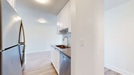 Located at 55 Bay Street in Victoria, BC, this one-bedroom, one-bathroom unit offers a well-organized and functional layout across a single floor. The open-concept living area is generously proportioned, finished with light-toned hardwood-style flooring that runs throughout, and brightened by crisp white walls that create a clean, airy atmosphere. A large sliding glass door in the living room opens to a balcony, flooding the space with natural light and providing views of the surrounding neighbourhood.

The kitchen is neatly positioned adjacent to the living area, featuring white cabinetry, a subway tile backsplash, and stainless steel appliances including a built-in microwave and oven range. A peninsula counter provides additional workspace and helps define the kitchen from the living space.

The bedroom offers a comfortable footprint with a large window that brings in natural light, a closet with sliding doors, and the same warm flooring found throughout the unit. Baseboard heating is present in both the living room and bedroom.

The bathroom is finished in a bright, contemporary style with large-format tile flooring, a white vanity with an undermount sink, and a full bathtub with a classic white subway tile surround and chrome fixtures. The overall aesthetic throughout the unit is clean, modern, and move-in ready.