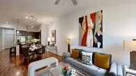Located at 1900 Yorktown St in Houston's desirable Galleria corridor, this single-floor 2-bedroom, 3-bathroom residence offers a thoughtfully designed layout with refined finishes throughout. The open-plan living and dining area is anchored by warm hardwood flooring, elevated ceilings with ceiling fans, and large windows that invite abundant natural light and leafy outdoor views. The living room provides a comfortable, airy atmosphere, while the adjacent dining area flows seamlessly toward the kitchen. The kitchen is a standout feature, boasting rich dark wood cabinetry, granite countertops, a tile backsplash, stainless steel appliances, and a central island with pendant lighting and a built-in beverage cooler — ideal for both everyday cooking and entertaining. The spacious primary bedroom features a tray ceiling, ceiling fan, and plush carpeting, with double doors leading to a closet. The bathrooms are finished with granite vanity countertops, undermount sinks, and clean, neutral tile work. White panel doors and crisp walls are consistent throughout, lending the home a cohesive, polished aesthetic. The well-connected hallway and dedicated closet space add to the home's functional appeal.