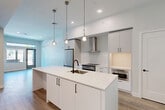 Located at 3103 Spruce St in Boulder, Colorado, this modern single-floor residence offers a thoughtfully designed layout across a comfortable footprint. The open-concept kitchen and living area serves as the heart of the home, anchored by a striking white quartz waterfall island with an undermount sink and matte black fixtures. The kitchen is outfitted with flat-front white cabinetry, stainless steel appliances including a French door refrigerator and range, a sleek stainless hood, and built-in shelving that provides ample storage. Pendant lighting with brass accents hangs above the island, adding a warm contrast to the clean, bright aesthetic. Light wood-style flooring flows throughout the main living area, complementing the white walls and crisp trim. The living area benefits from natural light through a glass door and transom window that frame views of the surrounding neighborhood. The bedroom features plush carpet, generous corner windows that invite in natural light, and a closet with built-in shelving and hanging rods. The bathroom is finished with white subway tile in the tub-shower surround, matte black fixtures, a wood-toned vanity with a white countertop, and a large illuminated mirror. A dedicated closet completes this well-appointed Boulder residence.