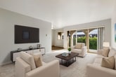 This 820 square foot apartment offers a well-designed layout with 2 bedrooms and 2 bathrooms. The open-plan living area combines the kitchen, dining, and living spaces, creating a sense of spaciousness. The kitchen features white cabinetry, light countertops, and modern appliances, with a galley-style layout for efficiency.

The primary bedroom, measuring 160 square feet, provides ample space and includes a large window for natural light. Both bedrooms are carpeted and decorated in neutral tones, with the primary bedroom showcasing a decorative wall hanging and round area rug.

The bathrooms are clean and functional, with one featuring a vanity and mirror. The living room is tastefully furnished with a light grey sofa, wooden coffee table, and rattan accent chair. Large windows and sliding glass doors in the living area lead to an outdoor space, likely a balcony or patio.

Throughout the apartment, a cohesive color scheme of whites, greys, and light woods is complemented by touches of blue in the furnishings. The flooring alternates between carpet in the bedrooms and wood-look laminate in the main living areas and kitchen. Overall, the space exudes a modern, minimalist aesthetic with attention to both style and functionality.