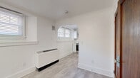 Located at 16 Chapel Road in Buffalo, NY, this efficiently designed one-bedroom, one-bathroom unit offers a thoughtfully renovated interior that maximizes every square foot. The space is finished with light-toned tile flooring throughout, crisp white walls, and clean crown molding that lend a bright, cohesive aesthetic from room to room.

The entry area welcomes you with a classic solid wood door and a flush-mount ceiling light, setting a clean and functional tone. A standout architectural detail is the elegant arched doorway connecting the living area to the kitchen, adding a touch of character to the otherwise modern interior. Multiple windows fitted with white horizontal blinds allow natural light to filter in throughout the space.

The kitchen is well-appointed with white shaker-style cabinetry, a stainless steel refrigerator, a stainless steel electric range, and a stainless steel hood vent — offering a complete and contemporary cooking setup.

The spacious primary bedroom provides a comfortable retreat, while the full bathroom features a clean, all-white design with a pedestal-style sink, a standard toilet, and a full soaking tub with shower, accented by white subway tile and a natural light window. A wall-mounted unit heater ensures year-round comfort. This unit is an ideal option for those seeking a clean, move-in-ready space in the Buffalo area.