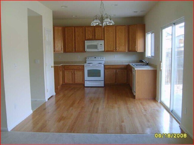 This is a good look at the entire kitchen but it is an old photo before the updated BLACK appliances were installed. - 10289 hadrian ct