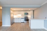 Located at 335 Melvin Ave in Hamilton, Ontario, this well-appointed 2-bedroom, 1-bathroom unit is laid out efficiently across a single floor, offering a clean and modern living environment. Light-toned vinyl plank flooring flows consistently throughout, lending the space a cohesive and contemporary feel.

The kitchen is a standout feature, showcasing white shaker-style cabinetry with brushed nickel hardware, white subway tile backsplash, light stone countertops, and a full suite of stainless steel appliances including a range, over-the-range microwave, and dishwasher. Recessed lighting adds a polished finish overhead.

The living room is bright and open, benefiting from a large picture window that frames views of mature trees, while a wall-mounted ductless mini-split unit provides efficient heating and cooling. Crown moulding adds a refined architectural touch.

The primary bedroom is generously sized and features a closet with classic panel doors, while the second bedroom is a comfortable, well-proportioned room with its own closet. Both rooms are finished in soft grey tones with clean white trim.

The bathroom is neatly appointed with a tiled tub-shower combination, light vinyl flooring, and a vanity with storage. The overall aesthetic of the unit is clean, neutral, and move-in ready.