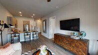 This thoughtfully designed one-bedroom, one-bathroom residence in Houston, TX (77008) offers a well-appointed single-floor layout that balances modern aesthetics with everyday functionality. The open-concept living and dining area flows seamlessly together, anchored by wood-look plank flooring, recessed lighting, and a ceiling fan. A large wall-mounted TV and a geometric-patterned dresser add character to the living space, while French doors with floor-to-ceiling drapes open to a private balcony, filling the room with natural light and offering outdoor views.

The kitchen is a standout feature, equipped with wood-toned cabinetry, a white subway tile backsplash, stone-look countertops, and a full suite of stainless steel appliances including a French door refrigerator, range, and built-in microwave. A peninsula with seating for multiple bar-height chairs serves as both a prep area and casual dining spot.

The bedroom is a calm retreat with plush carpeting, large windows with roller shades, a ceiling fan, and ample natural light. The full bathroom is finished with large-format tile flooring, a single vanity with a light stone countertop, and a glass-enclosed walk-in shower, rounding out this well-crafted residence.