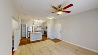 Located in Youngsville, Louisiana, this 1-bedroom, 1-bathroom single-floor residence offers a thoughtfully designed open-concept layout. The living area features neutral-toned carpet, a ceiling fan with light fixture, and a seamless flow into the kitchen, creating a welcoming and functional shared space. The kitchen is a standout feature, equipped with stainless steel appliances — including a French door refrigerator, electric range, built-in microwave, and dishwasher — complemented by gray shaker-style cabinetry, granite-look countertops, and wood-look flooring. A curved kitchen island with pendant lighting above adds both style and additional workspace. Track lighting and pendant fixtures provide ample illumination throughout the kitchen. The bedroom is generously proportioned, featuring plush carpet, a ceiling fan, and two windows that invite natural light. The full bathroom is well-appointed with a granite-top vanity, gray cabinetry, wood-look flooring, and a shower/tub combination. Clean white walls and consistent neutral tones carry throughout the space, contributing to a bright, cohesive aesthetic. The overall design emphasizes practicality and comfort, making efficient use of every area within this single-level home.