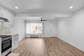 Located at 6933 Rosemead Blvd, this single-floor unit presents a clean, modern aesthetic defined by bright white walls, light wood-tone flooring, and recessed lighting throughout. The open-concept layout seamlessly connects the living area to the kitchen, creating a cohesive and functional living space.

The kitchen is thoughtfully designed with white shaker-style cabinetry extending to the ceiling, offering generous storage. A quartz-style countertop with subtle veining provides an elegant work surface, complemented by a stainless steel double-basin sink, a stainless steel range with oven, and a ventilation hood. A marble-look backsplash ties the design together.

The living area is spacious and airy, featuring a sleek black ceiling fan, a wall-mounted AC unit, and a large window dressed with vertical blinds that allow natural light to filter through. An additional dedicated area features a tall bank of built-in white shaker cabinets with brushed nickel hardware, offering substantial storage capacity.

The bathroom maintains the unit's consistent design language with a white vanity, quartz countertop, undermount sink, wall-mounted mirror, overhead cabinetry, and white subway tile. The overall ambiance is fresh, minimalist, and move-in ready.