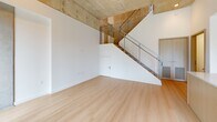 Located at 222 N City Dr in San Marcos, CA, this two-story, 2-bedroom, 2-bathroom home offers a thoughtfully designed modern interior with a clean, minimalist aesthetic throughout. Light wood flooring flows seamlessly across both levels, complementing the crisp white walls and creating a bright, cohesive atmosphere.

The main floor serves as the social hub of the home, featuring an open-concept kitchen with light wood cabinetry, stainless steel appliances, a central island with an integrated dining extension, and an exposed concrete ceiling that adds an industrial character. Large sliding glass doors open to an outdoor area, inviting abundant natural light and providing easy indoor-outdoor access. A sleek staircase with metal cable railings connects the two floors, adding a contemporary architectural focal point.

The upper level houses the bedrooms, each benefiting from generous natural light through large modern windows framing views of the surrounding greenery and neighborhood. The primary bedroom includes a built-in wardrobe with light wood finishes, offering practical storage in a refined package. Both bathrooms are finished with warm wood vanities, illuminated mirrors, and light flooring, maintaining the home's consistent modern palette. A hallway connects the upper-level rooms efficiently. This home combines clean design with functional living in a desirable San Marcos location.