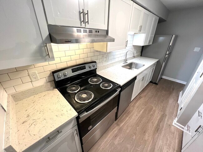Bright white kitchen with stainless steel appliances, shaker cabinets and quartz countertops - 2030 Quaker Landing